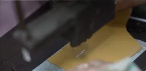 Seorang desainer menyiapkan sketsa teknis desain sepatu di atas meja kerja pabrik untuk persiapan produksi.