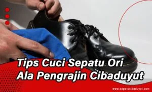 Seorang pengrajin sedang melakukan perawatan atau penyemir pada sepatu kulit berwarna tan di workshop sepatu.